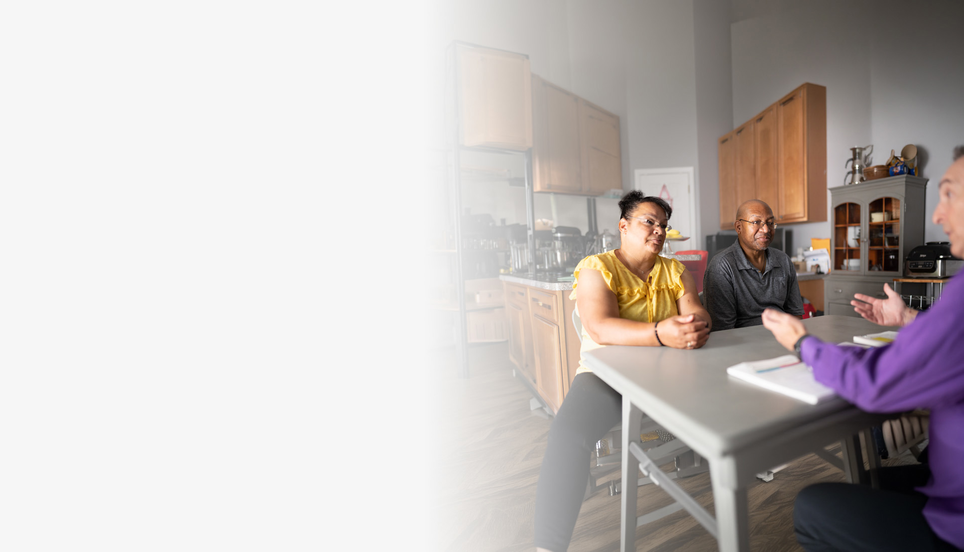 Wounded warrior Richard Daniel and his wife, Mina, sit at a table discussing their finances with a financial planner.